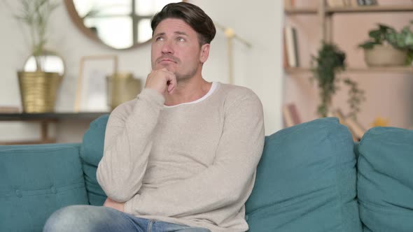 Middle Aged Man Sitting and Thinking , at Home