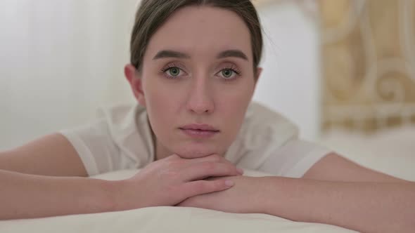 Close Up of Young Woman Looking at the Camera in Bed