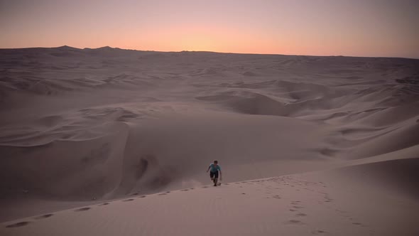 Sunset adventure up a sand dune in the desert while travelling on a gap year, Huacachina, Peru