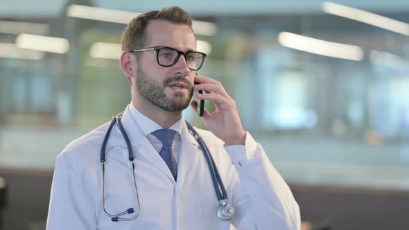 Portrait of Young Male Doctor Talking on Smartphone