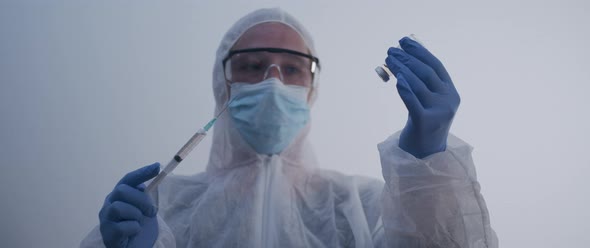 Woman pulling out a syringe from a bottle and lowering the hand with syringe slow motion