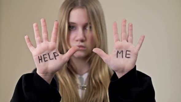 Portrait of a Frustrated Teenage Girl Showing Her Palms with the Inscription HELP ME