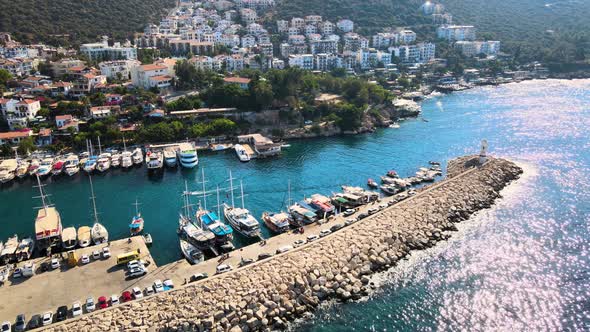 Close-up drone flight over the water surface of the yacht boat mooring against the backdrop of a res