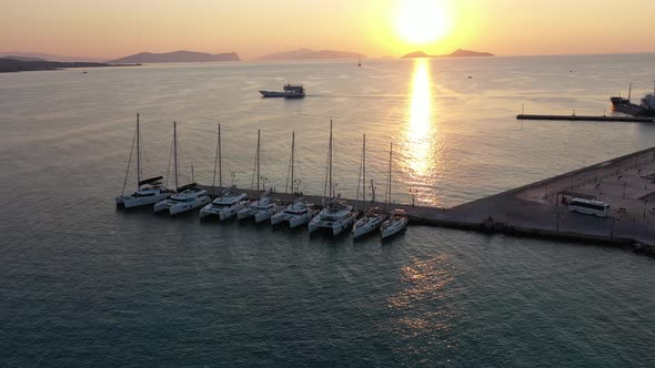 Catamaran and Sail Yachts Anchored at Bay on Deep Blue Sea Water on Sunrise