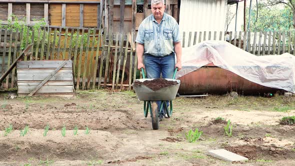 A Man in a Cart Carries Compost or Rot