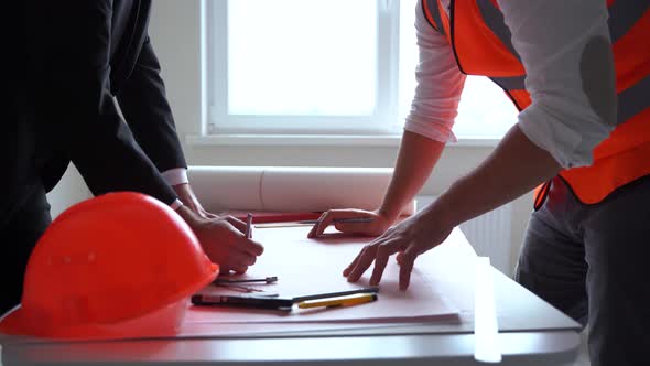 Close Up Side View of Businessman and Male Contractor Talking and Shaking Hands