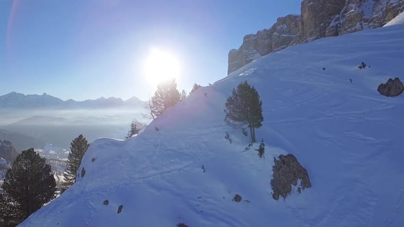 Flight through snowy landscape, Dolomites at sunrise, Italy