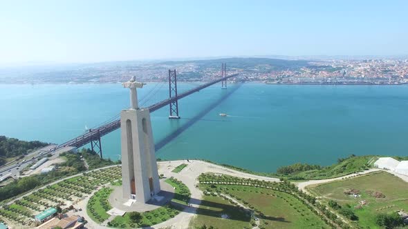 Aerial view of Sanctuary of Christ the King overlooking Lisbon and 25 de Abril Bridge connecting Lis