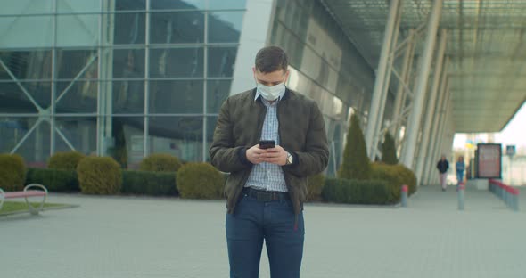 Young Man Wearing Protective Face Mask Use Phone COVID-19 Coronavirus Infection Near Airport