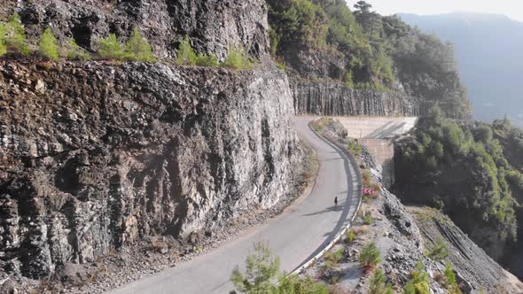 Road cyclist climbing mountain road. Athlete cycling on mountain pass.