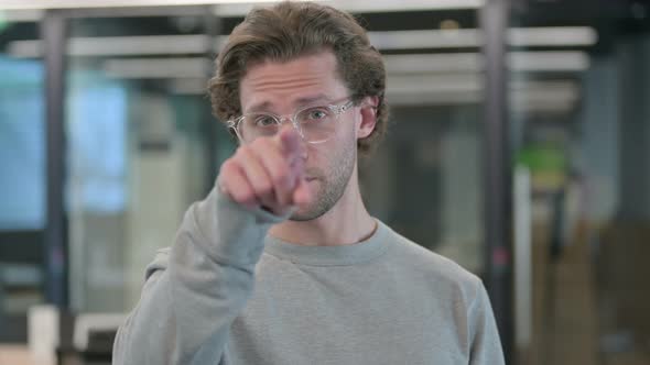 Portrait of Young Businessman Pointing at Camera Inviting