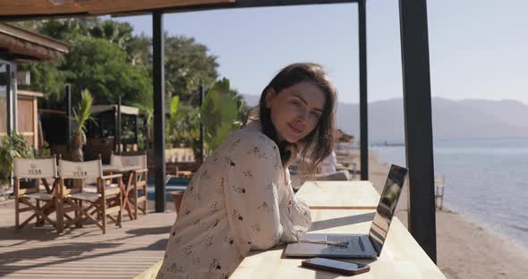 Woman Working on Laptop in Coastline in Summer Sunny Day. Female Freelancer