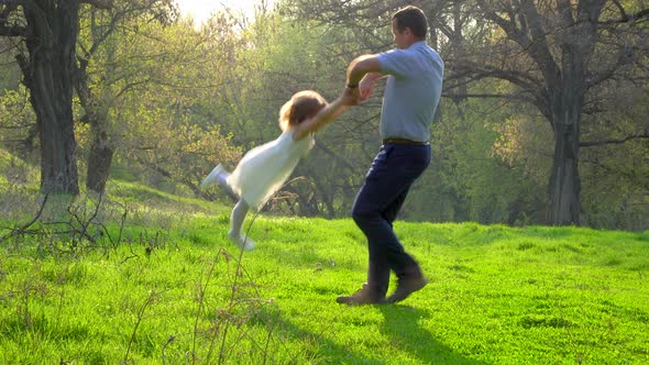 Dad Plays with His Daughter in the Park