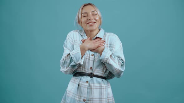 The Happy and in Love Young Woman Holds Her Hands to Her Chest and Hugs Smiling Wide