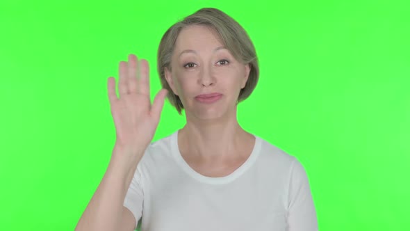 Old Woman Waving Hand to Say Hello on Green Background