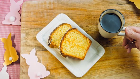 The Woman Puts a Cup of Coffee on the Table Where There is a Chocolate Cake