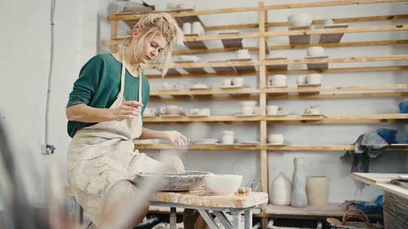 Female Potter Creating at Workshop Sculpting Crockery on Pottery Wheel Tracking Shot Slow Motion