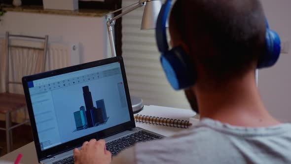 Male Architect Looking at Building Model on Laptop