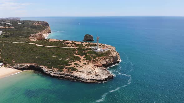 Aerial shot towards Ponta do Altar lighthouse epic cliff coastline, Ferragudo