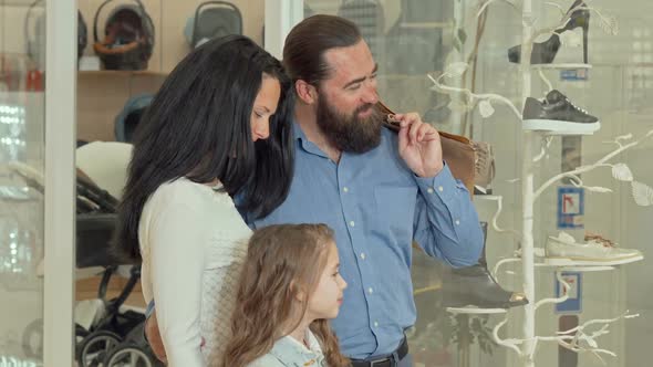 Lovely Family Looking at the Display of Clothing Store at Shopping Mall