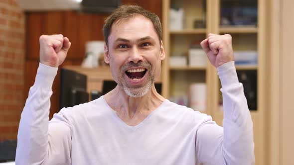 Excited Middle Age Man Celebrating Success in Office