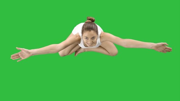 Woman sitting in lotus pose and looking up to camera on