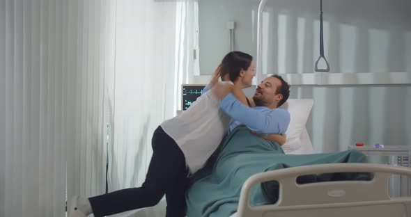 Wife Visiting and Hugging Ill Husband in Hospital Room