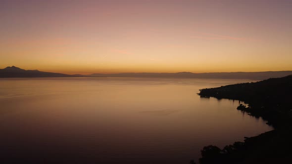 Aerial shot descending towards Lake Léman with beautiful sunset colorsCully, Vaud - Switzerland