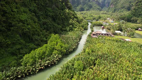 Aerial view of a river surrounded by jungle, mangroves, and limestone mountains. Filmed at a local v