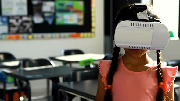 Schoolgirl using virtual reality headset in classroom 4k