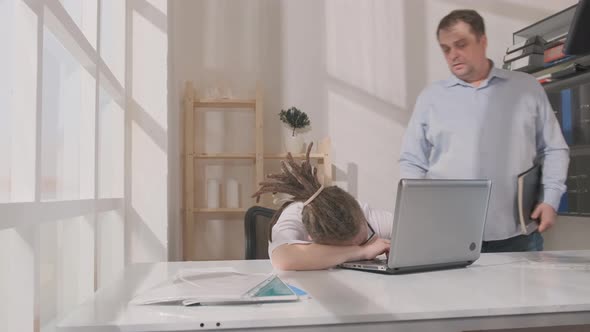 Woman sleeps in office at workplace during working day and wakes up when her boss or work colleague