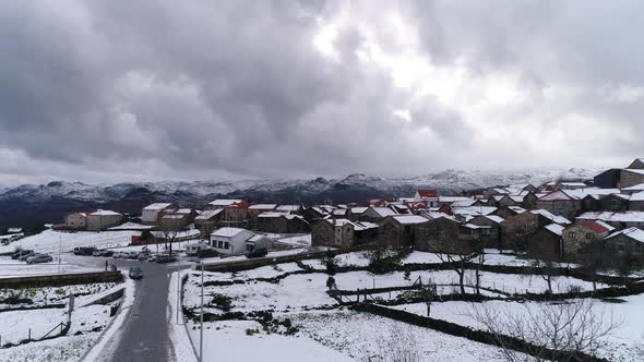 Mountain village buildings and houses on snowy hill slopes covered with snow