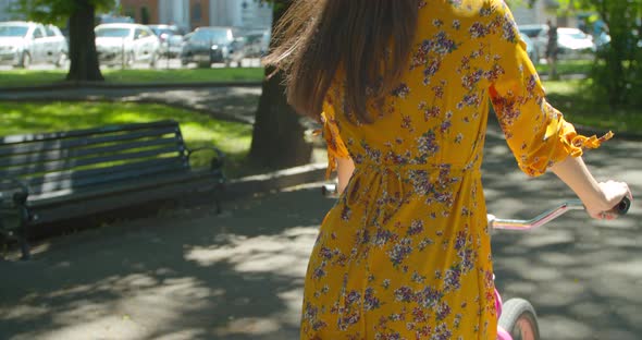 Cyclist Happy Woman On Bicycle. Adorable Cyclist Girl Wearing Dress Workout. Hair Blowing When Girl