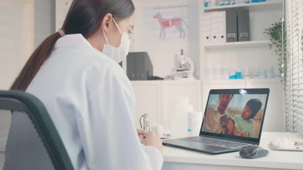 Asian veterinarian girl use laptop computer talk to pet owner on online virtual video call.