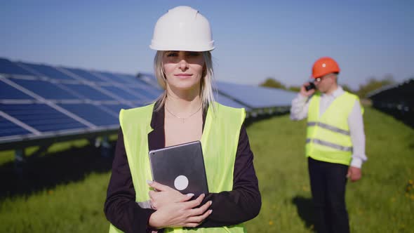 Portrait of Two Engineers in Special Uniforms with Protective White Helmets