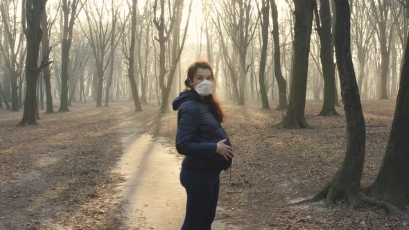 Pregnant Woman in Face Mask in the Woods. Toxic Smoke or Fog in the Forest at Sunset. Ecology