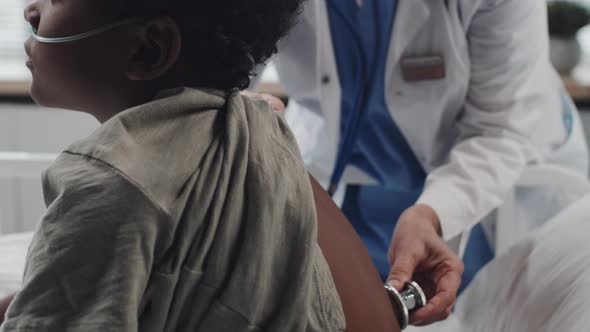 Female Doctor Using Stethoscope on Boy