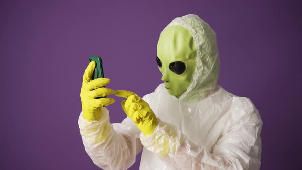 Green Alien Studies Human Technologies Showing Phone Screen