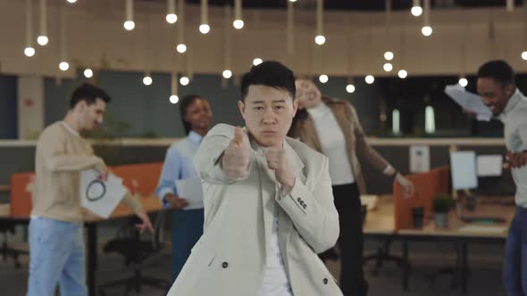 Funny Asian Businessman Dancing with Colleagues Celebrating Corporate Success Enjoy Office Party