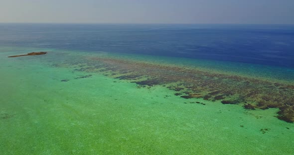 Wide angle drone clean view of a white sandy paradise beach and blue ocean background in colourful 4