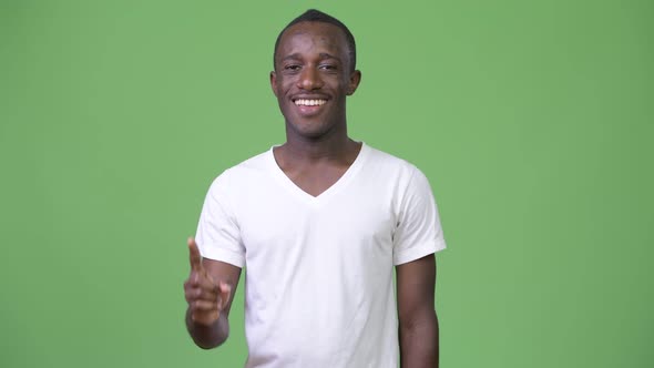 Young Happy African Man Smiling and Pointing Up