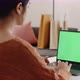 Young Asian woman using laptop computer at home with green blank monitor screen. - VideoHive Item for Sale