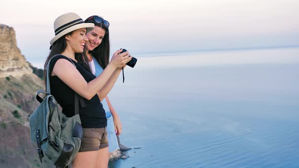 Two Attractive Female Traveler Taking Photo of Beautiful Sea Landscape Using Professional Camera