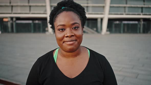 Close Up Portrait of Young Positive Overweight African American Lady Smiling to Camera Posing