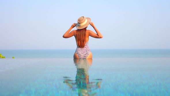 Young asian woman enjoy around outdoor swimming pool for leisure