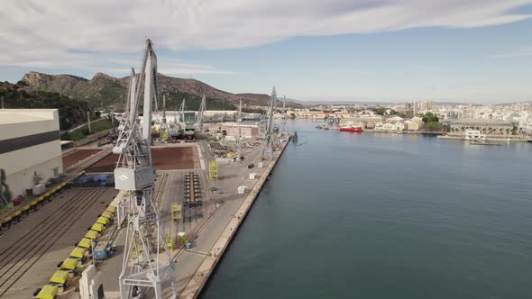 Drone flying along quay of Cartagena industrial port, Spain. Aerial forward