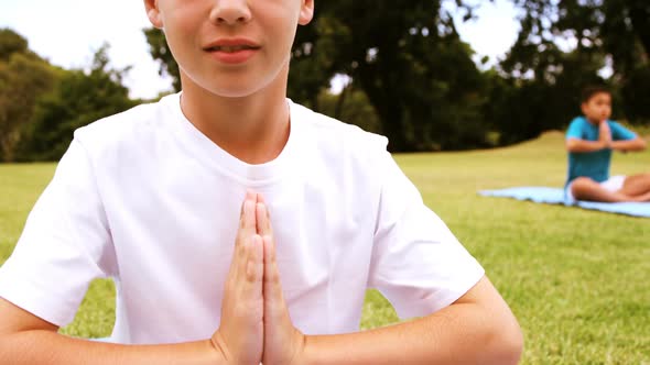 Portrait of boy performing yoga in park