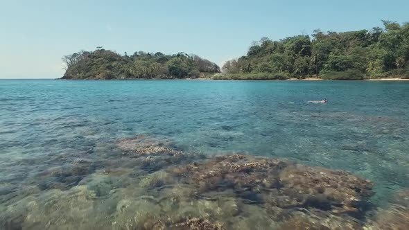 Low drone footage of Playa Blanca's clear water located on Panama.