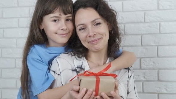 Portrait of a mother with a child with a gift.