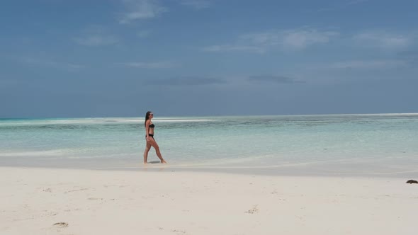Young Woman in Bikini Walk on an Empty Paradise Beach on Island in Ocean Mnemba